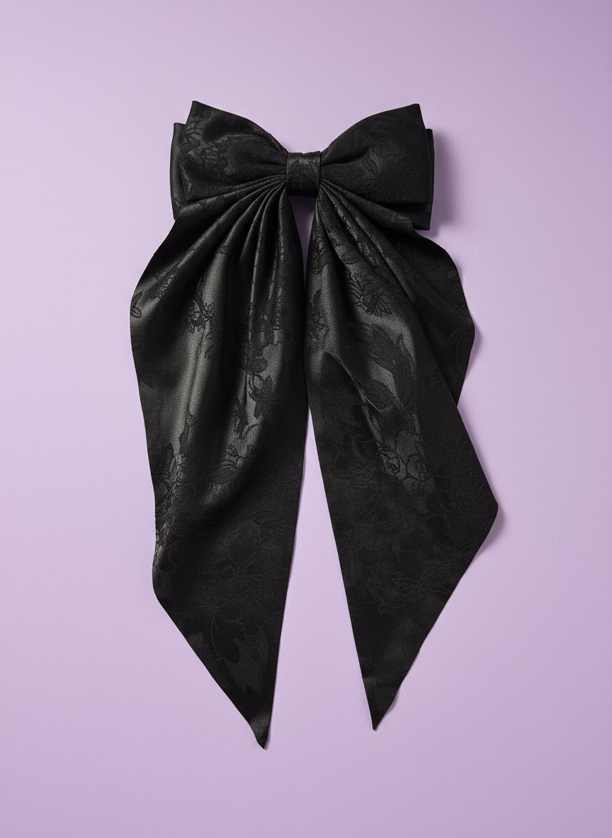 Black fabric on a white cutting board with a patterned background