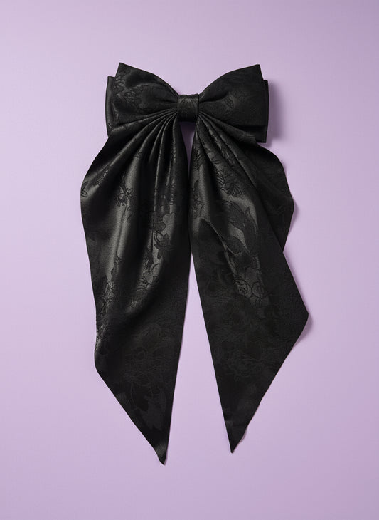 Black fabric on a white cutting board with a patterned background